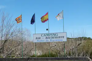 Camping Fuente de Regrustan - Flaggen und Schild des Campingplatzes