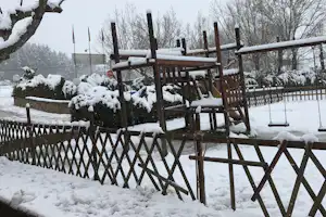 Camping Fuente de Regrustan - Spielplatz auf dem Campingplatz mit Rutsche und Schaukel im Winter