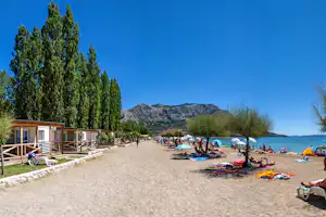 Camping Galeb - Mobilheime am Strand vom Campingplatz mit Camper im Schatten von Bäumen