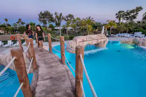 Yelloh! Village Gavina - Brücke über das Freibad im Poolbereich auf dem Campingplatz