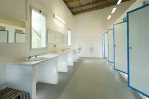 Camping Genova Est - Sanitärbereich vom Campingplatz mit Waschebcken, Spiegeln, Toiletten und Pissoirs