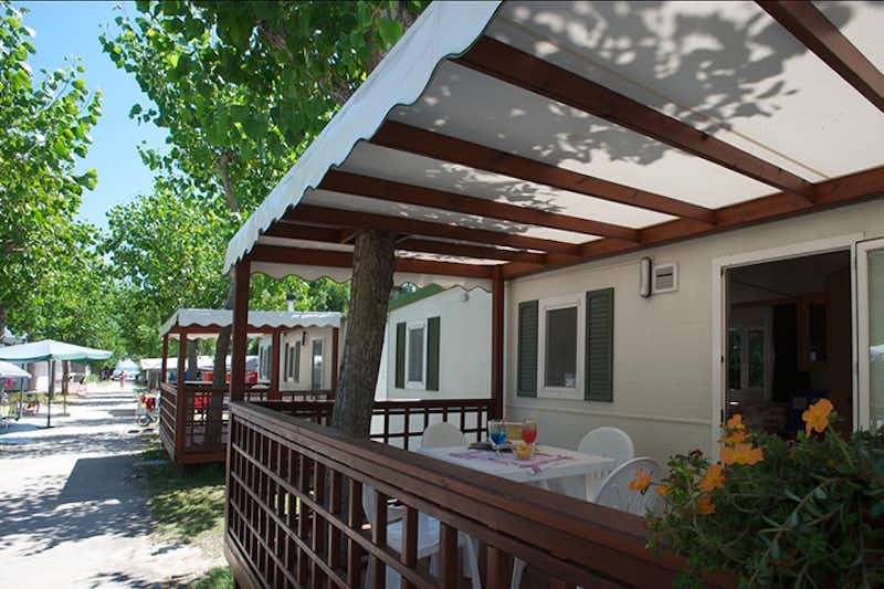 Camping Gilda - Mobilheime mit Veranda  im Schatten der Bäume auf dem Campingplatz