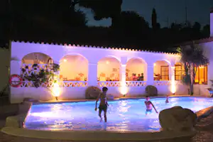 Camping Globo Rojo - spielende Kinder im Pool bei Nacht auf dem Campingplatz
