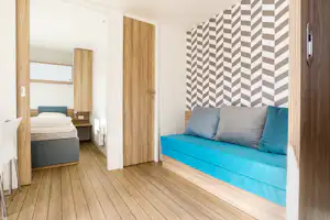 Nordic Camping Glyttinge - Innenansicht vom Mobilheim auf dem Campingplatz mit Sofa und Schlafbereich
