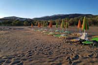 Camping Grammeno - Strand Kretas mit Strandliegen und Sonnenschirmen