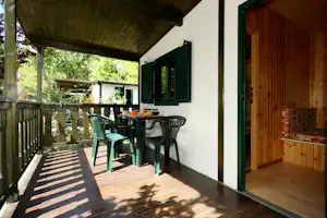Camping Green - Veranda eines Mobilheims mit Sitzgelegenheiten und Blick in den Innenraum des Mobilheims