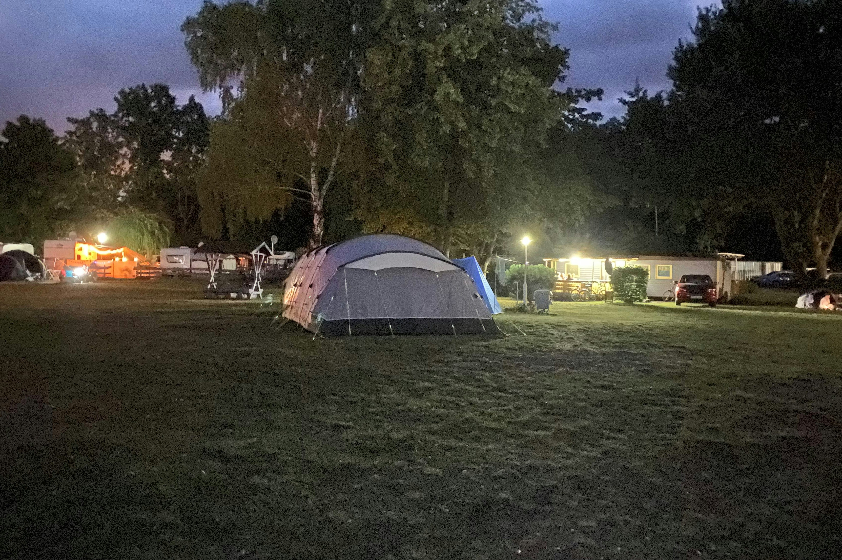 Themencamping Grünewalder Lauch  Camping Grünewalder Lauch - Blick auf die Standplätze auf der Wiese am Abend