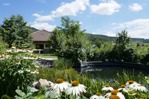 Camping & Guesthouse Sedliacky Dvor - Kleiner Teich umring von Blumen und Büschen auf dem Campingplatz