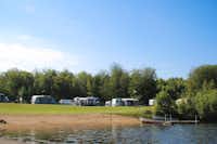 Camping Halen - Blick auf die Stellplätze am See mit Liegewiese und Bootsanlegestelle