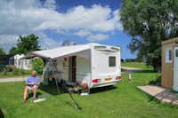 Camping Haliotis - Wohnmobil auf dem Campingplatz mit davor sitzendem Camper