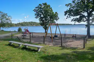 KustCamp Gamleby - Sandspielplatz mit Schaukeln und Rutsche nah am Wasser gelegen