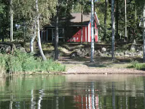 Wohnmobilstellplatz im Schatten der Bäume am See auf dem Campingplatz Herrfallet