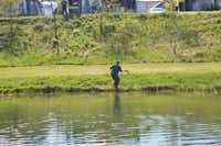 Camping Hessellund Sø - Angler am See, der einen Fisch in der Hand hält