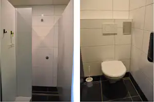 Modernes Badezimmer mit Toilette, Waschbecken und Duschbereich, Fliesenwände in hellen Farben und Tür im Vordergrund.