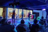 Camping Het Swinnenbos - abendliche Animation im durch Schirme überdachten Außenbereich