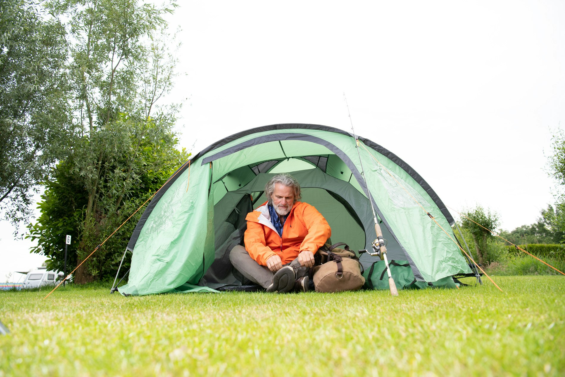 Camping Het Waterhoentje - Camper sitzt in seinem Zelt auf dem Campingplatz