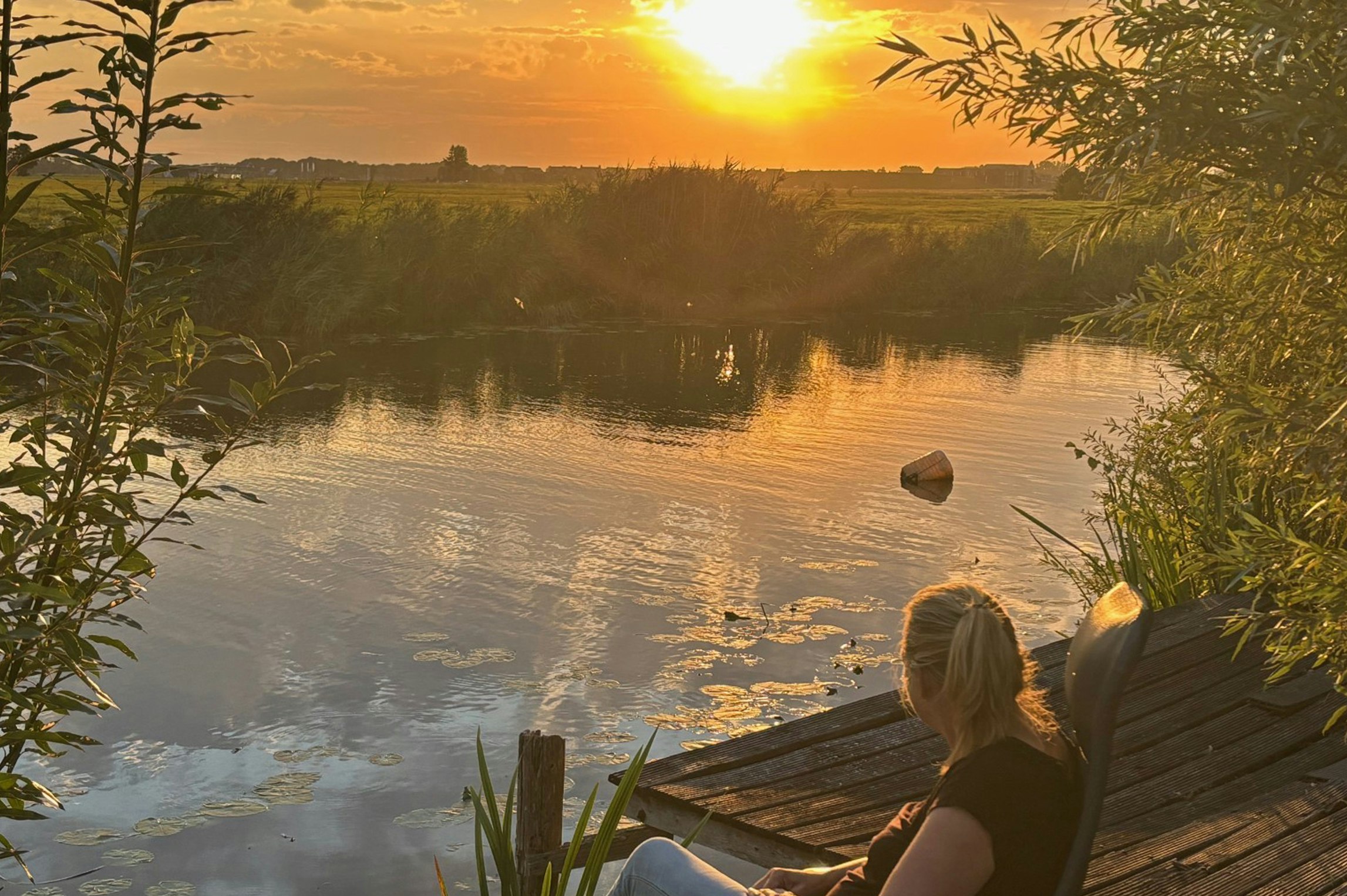Camping Hiddema State - Camperin genießt die Aussicht auf das Wasser bei Sonnenuntergang