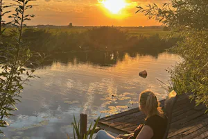 Camping Hiddema State - Camperin genießt die Aussicht auf das Wasser bei Sonnenuntergang