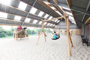 Camping Hindeloopen - Spielplatz in einer Halle mit Kletterburgen und Schaukeln