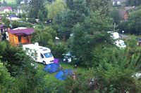 Camping Hirschegg  -  Luftaufnahme vom Stellplatz und den Mobilheimen auf dem Campingplatz zwischen Bäumen