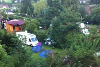 Camping Hirschegg  -  Luftaufnahme vom Stellplatz und den Mobilheimen auf dem Campingplatz zwischen Bäumen