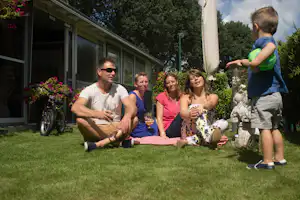 Camping Houtum - Camper Familie auf grüner Wiese am Mobilheim vom Campingplatz