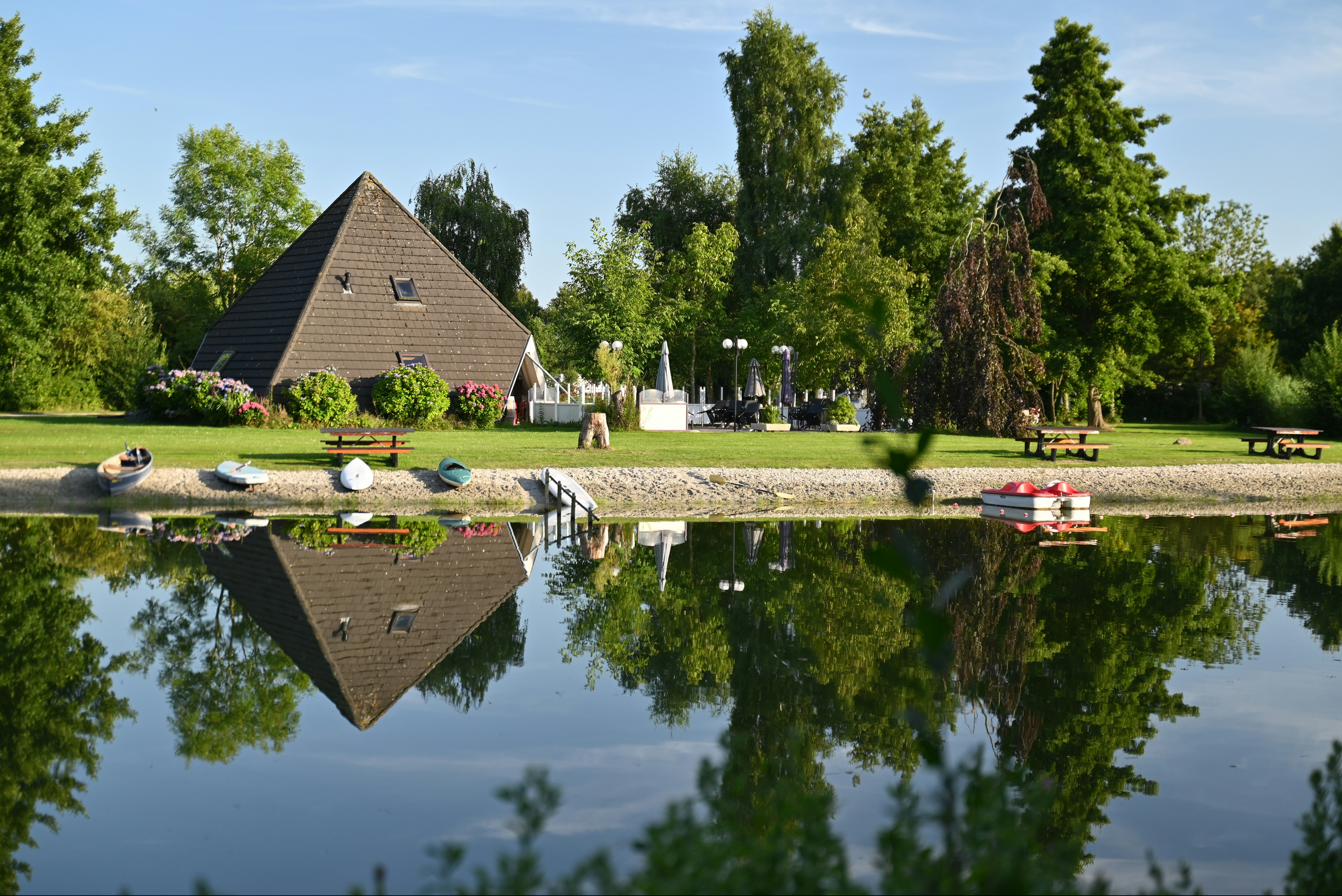 Camping Hunze Bulten - Blick auf das Ufer des Sees mit Wiese und Picknickbänken