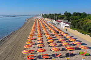 Camping I Tre Moschettieri - Sonnenschirme am Strand des Campingplatzes