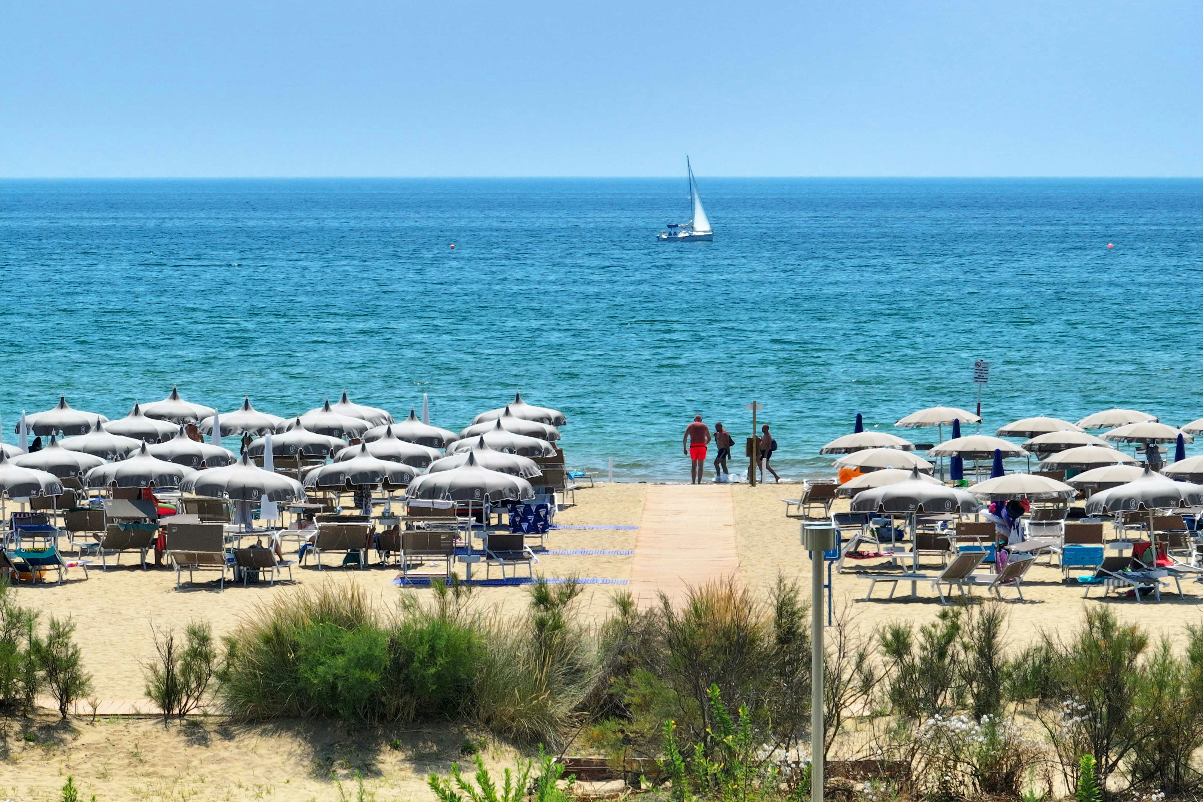 Il Tridente Camping Village  Camping Il Tridente - Blick auf die Liegestühle und Sonnenschirme am Badestrand