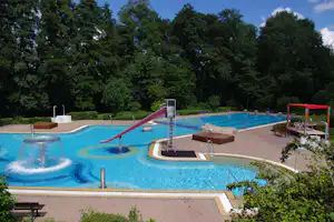 Luftaufnahme des Freibades mit Schwimmbahnen und Wasserrutsche
