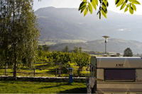 Camping im Park  -  Wohnwagen auf dem Stellplatz vom Campingplatz mit Blick auf die Alpen