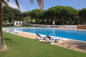 Camping Internacional Palamós - Poolbereich vom Campingplatz mit Liegestühlen in der Sonne im Grünen