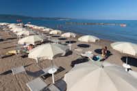 Camping International Argentario - Strand mit Liegestühlen und Sonnenschirmen