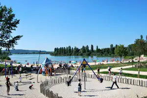 Camping International du Lac - Camper auf dem Spielplatz vom Campingplatz am Strand vom See