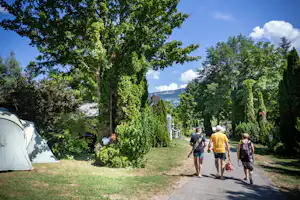 Camping Huttopia Lac d’Aiguebelette - Camper spazieren auf dem grünen Gelände vom Campingplatz