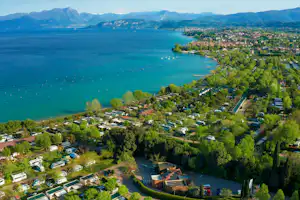 Camping La Quercia Camping Internazionale La Quercia - Luftaufnahme des Campingplatzes am Wasser mit Bergen im Hintergrund