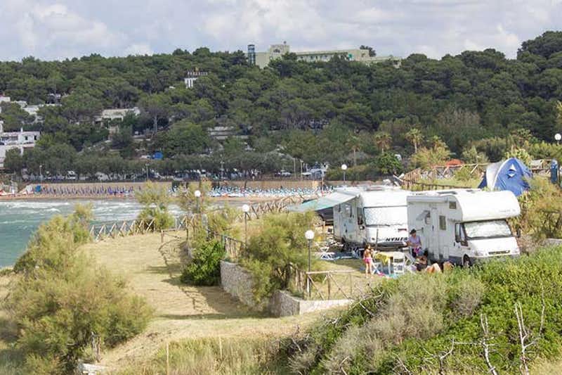 Camping Internazionale Manacore - Wohnmobile auf Stellplätzen mit dem Strand des Mittelmeeres im Hintergrund