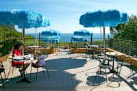 Camping Internazionale - Terrasse mit Sitzgelegenheiten und Sonnenschirmen mit Blick auf das Mittelmeer