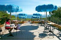 Camping Internazionale - Terrasse mit Sitzgelegenheiten und Sonnenschirmen mit Blick auf das Mittelmeer