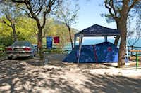 Camping Internazionale - Zelt auf einem Stellplatz zwischen Bäumen mit Blick auf das Mittelmeer