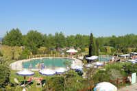Camping Italia  -  Poolbereich vom Campingplatz mit Sonnenschirmen und Liegestühlen auf grüner Wiese