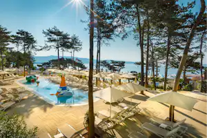 Camping Ježevac - Pool vom Campingplatz mit Sonnenschirmen und Liegestühlen und Blick auf das Meer
