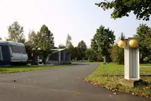 Camping Jennersdorf - Wohnwagenstellplatz zwischen Weg und Park auf der Wiese der Campingplatzanlage