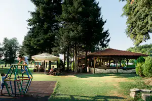 Camping Kapinovski Monastery - Kinderspielplatz mit Sitzgelegenheiten im Hintergrund und Pavillon
