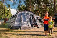 Camping Kiefernhain - Kinder vor dem Zelt umringt von Wald