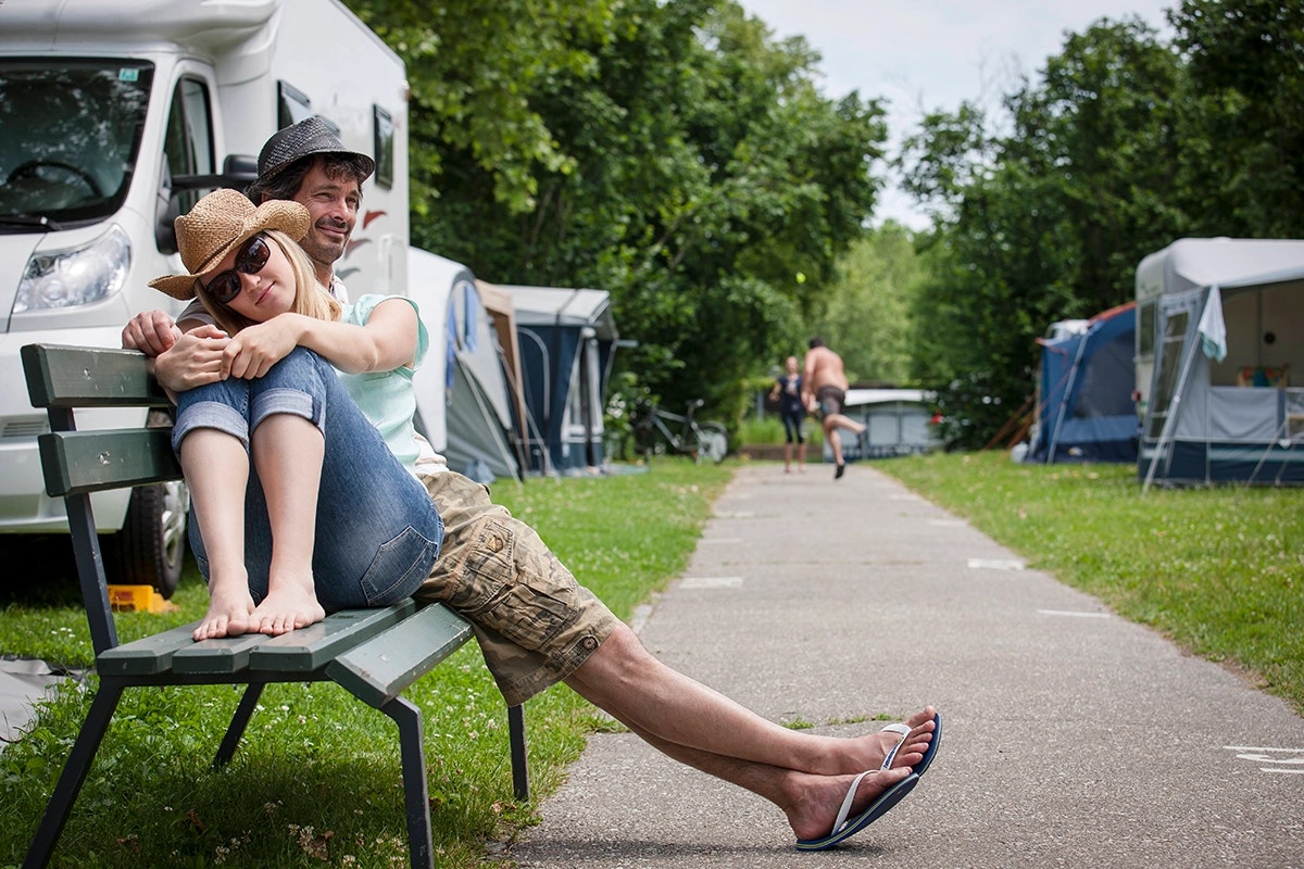 Camping Klagenfurt am Wörthersee - Camper sitzen auf einer Bank auf der Standplatzwiese