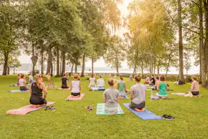 Camping Klausenhorn - Camper beim Yoga auf einer grüner Wiese vom Campingplatz am Bodensee