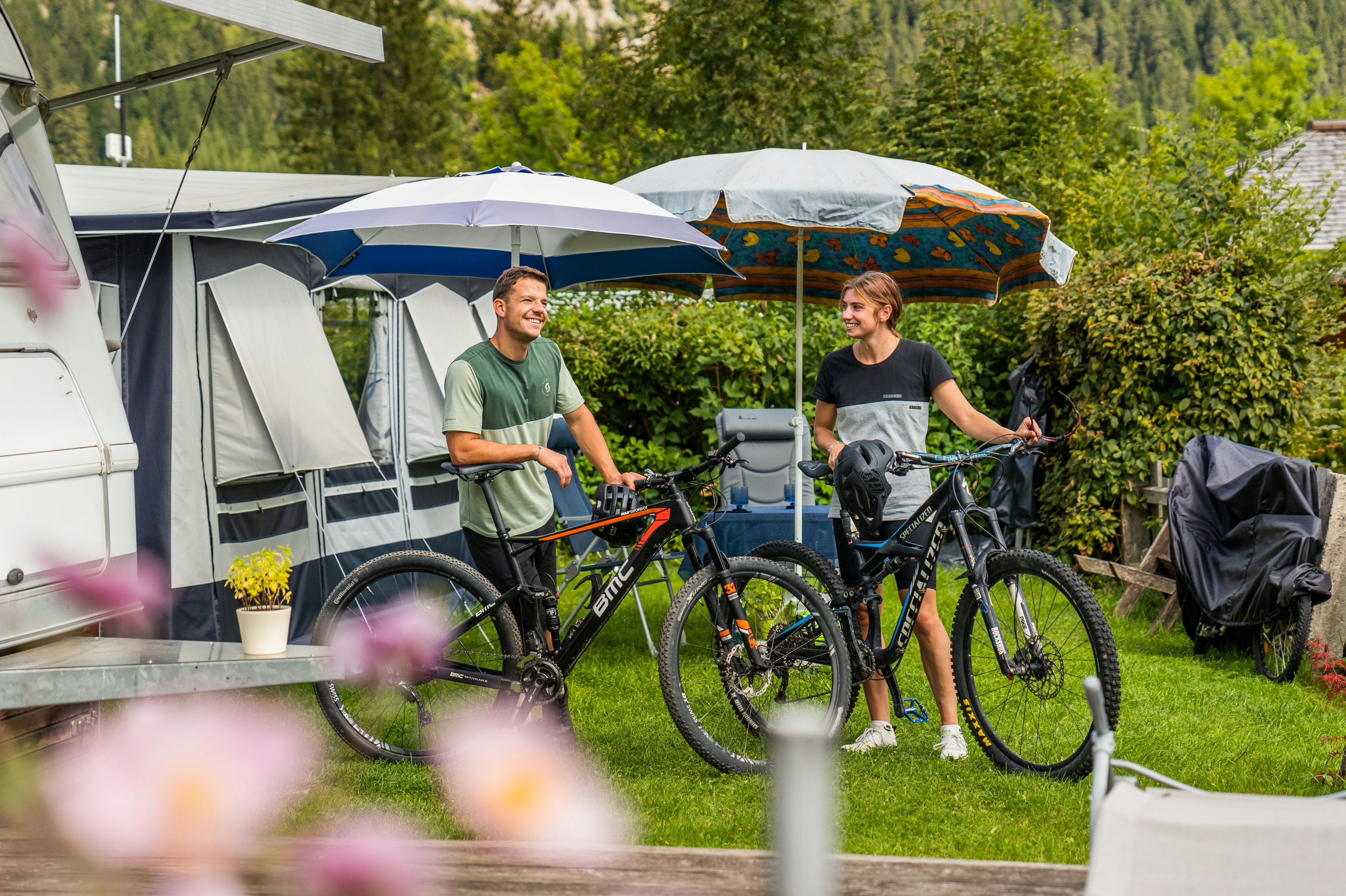 Camping Knaller - Camper mit Fahrrädern vor ihrem Wohnwagenstandplatz