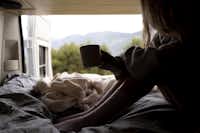 Camping Komodo Gargazon - Frau genießt den Morgen in einem Campervan