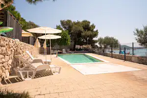 Camping Kozarica - Pool im Freien mit Liegestühlen und Sonnenschirmen